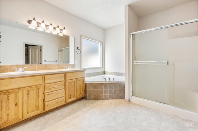 full bath with a garden tub, a stall shower, and a sink