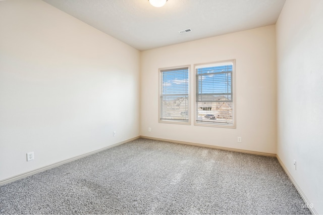 unfurnished room featuring light colored carpet, visible vents, and baseboards