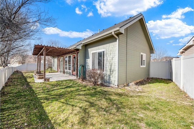 rear view of house featuring a yard, a patio, and a fenced backyard