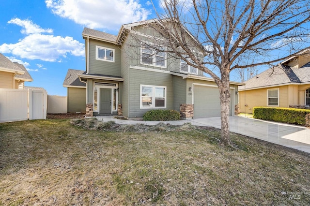 craftsman-style house with concrete driveway, fence, and a front yard