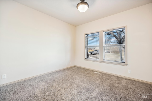 spare room featuring visible vents, baseboards, and carpet