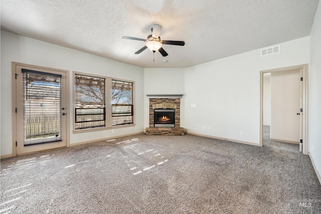 unfurnished living room with a stone fireplace, a textured ceiling, and a healthy amount of sunlight