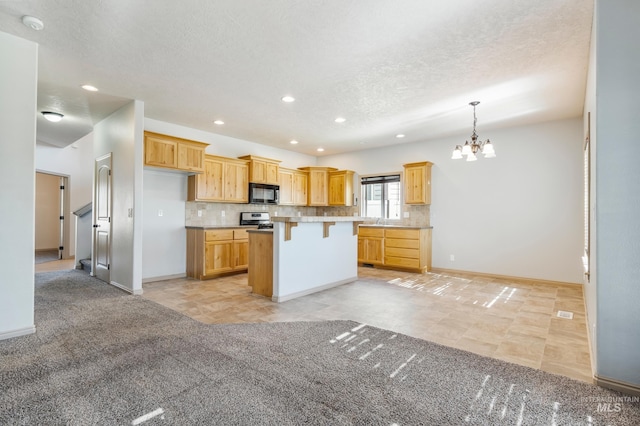 kitchen with a breakfast bar area, backsplash, stainless steel range oven, and black microwave