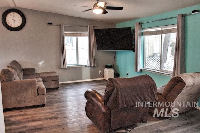 living area with vaulted ceiling, ceiling fan, wood finished floors, and baseboards