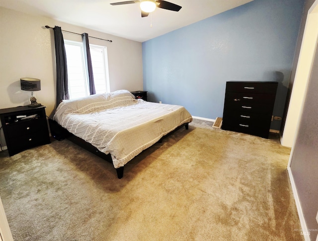 carpeted bedroom with a ceiling fan and baseboards