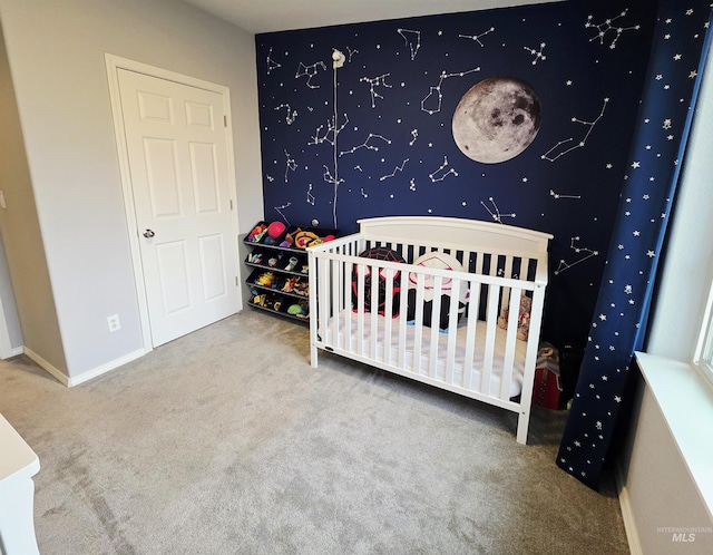 bedroom featuring a nursery area, carpet floors, and baseboards