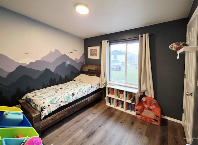 bedroom with baseboards and wood finished floors