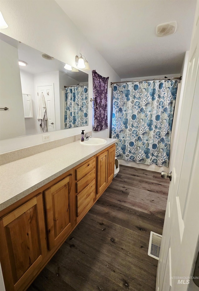 bathroom featuring visible vents, vanity, and wood finished floors