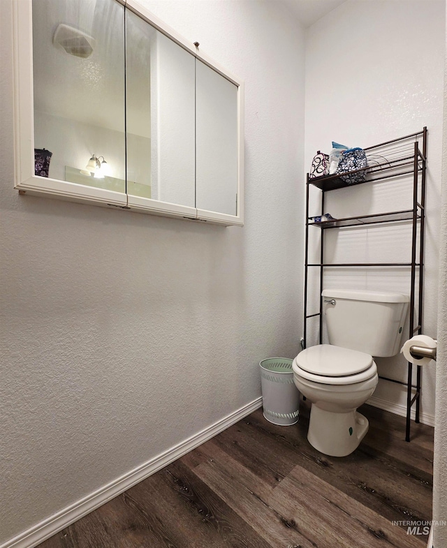 bathroom featuring toilet, baseboards, and wood finished floors