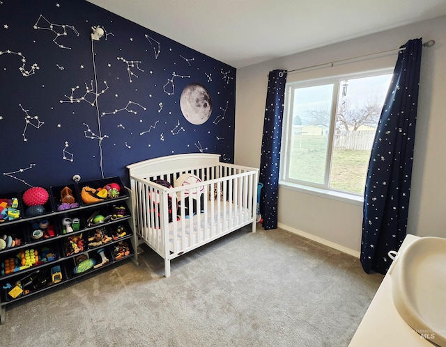 bedroom featuring carpet, a sink, a crib, and baseboards