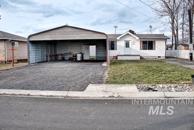 view of front of home with a carport, crawl space, driveway, and a front lawn