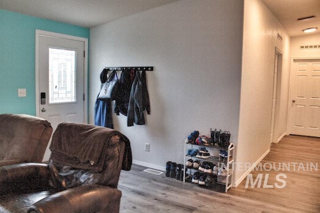 interior space with baseboards, visible vents, and wood finished floors