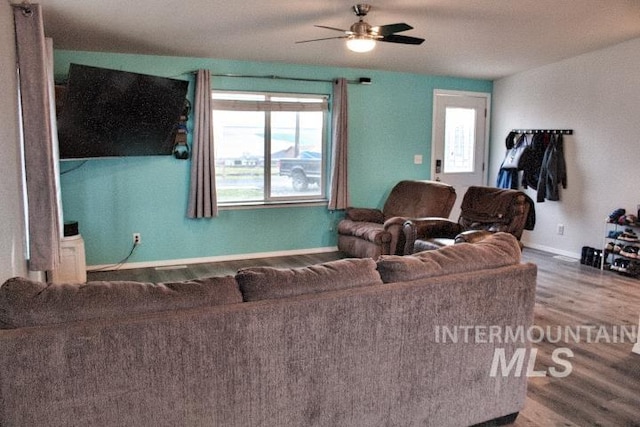 living area with ceiling fan, baseboards, and wood finished floors