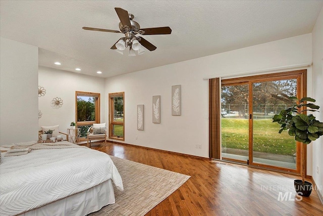 bedroom with hardwood / wood-style floors, ceiling fan, access to exterior, and a textured ceiling