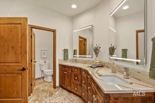 bathroom featuring decorative backsplash, vanity, and toilet