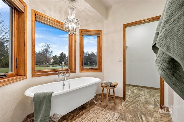 bathroom featuring a tub to relax in and an inviting chandelier