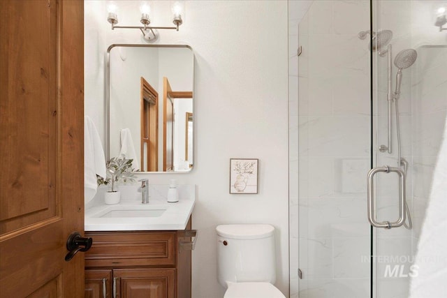 bathroom with toilet, vanity, and walk in shower