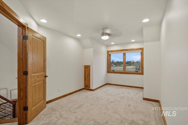 spare room with ceiling fan and light colored carpet