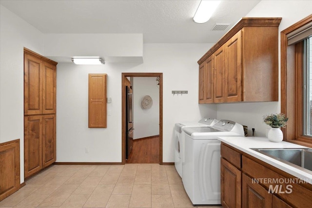 washroom with washer and clothes dryer and cabinets