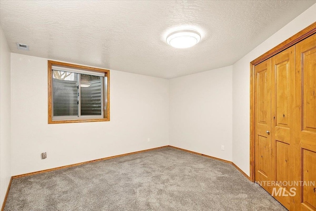 unfurnished bedroom featuring a closet, carpet, and a textured ceiling