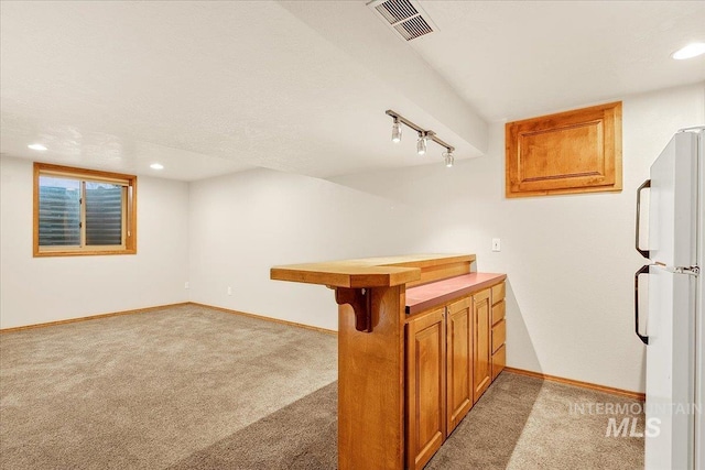 bar featuring carpet flooring, white refrigerator, and track lighting