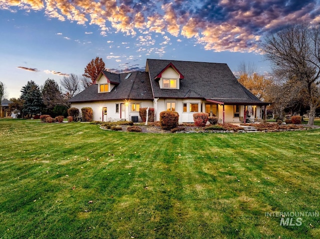 back house at dusk with a lawn