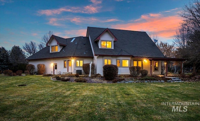 back house at dusk with a lawn