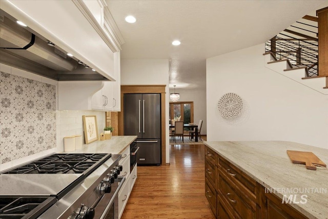 kitchen featuring backsplash, crown molding, dark hardwood / wood-style floors, premium appliances, and custom range hood