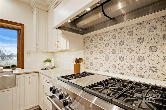 kitchen featuring custom range hood, tasteful backsplash, high end stainless steel range oven, and light stone counters