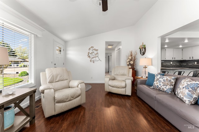 living area featuring baseboards, a ceiling fan, dark wood-style flooring, and vaulted ceiling