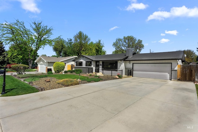 single story home featuring a front lawn, a garage, a gate, fence private yard, and driveway