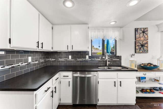kitchen with a sink, dark countertops, white cabinets, and dishwasher