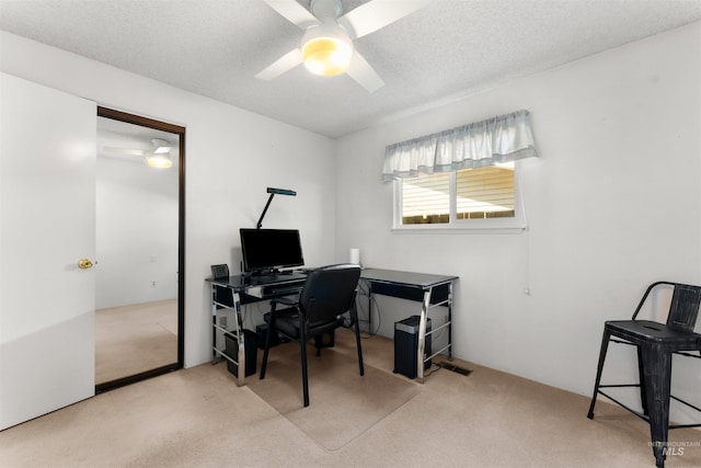 office space featuring a ceiling fan, carpet flooring, and a textured ceiling