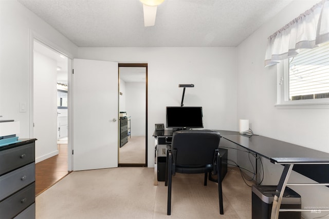 office space with a textured ceiling and light carpet