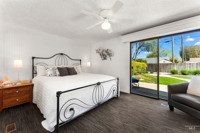 bedroom with visible vents, dark carpet, ceiling fan, access to outside, and a textured ceiling