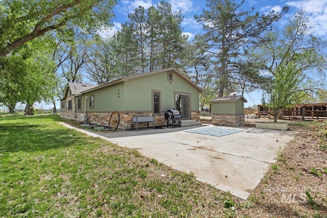169W 200 N, Jerome, ID 83316 - back of house with stone siding, a patio area, and stucco siding