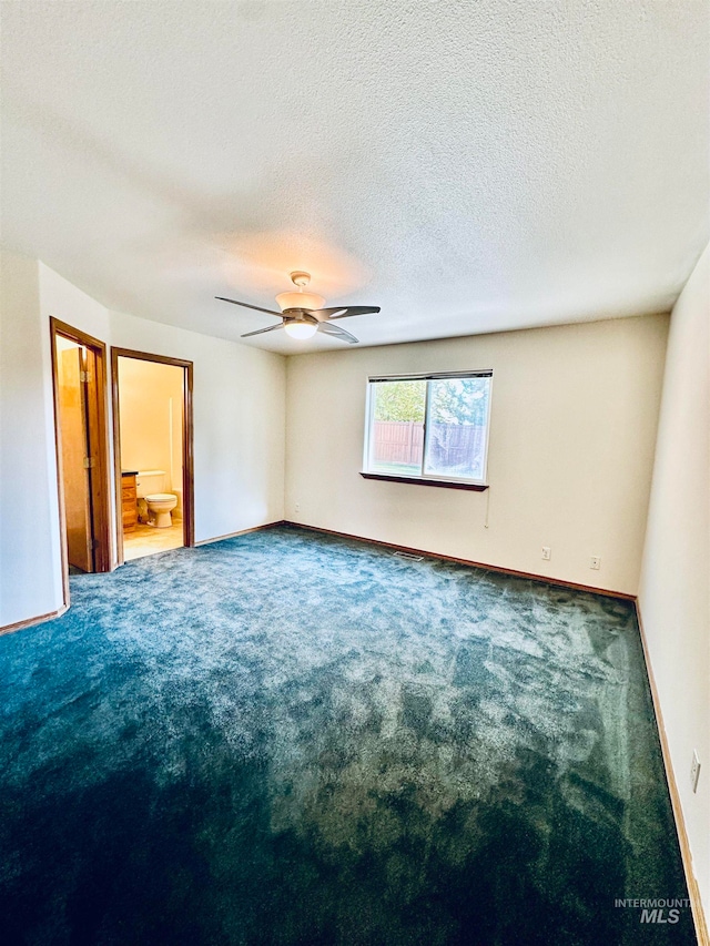 carpeted empty room with a textured ceiling and ceiling fan