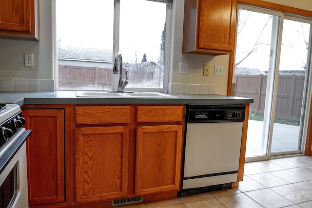 kitchen with sink, light tile patterned floors, and white appliances