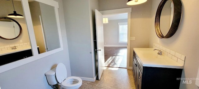 102 N Main St, Council, ID 83612 - bathroom with toilet, vanity, baseboards, and decorative backsplash