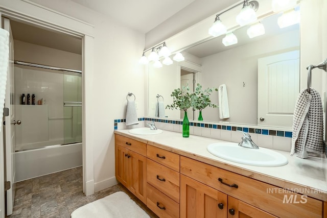 bathroom featuring decorative backsplash, vanity, and enclosed tub / shower combo