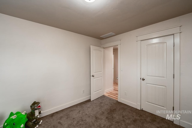 unfurnished bedroom featuring dark colored carpet