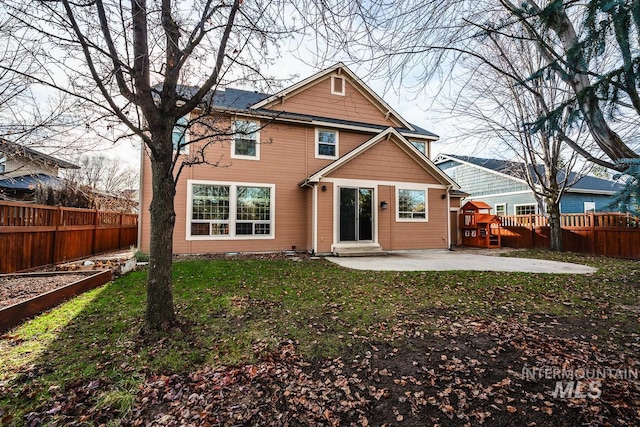 rear view of property featuring a patio area and a yard