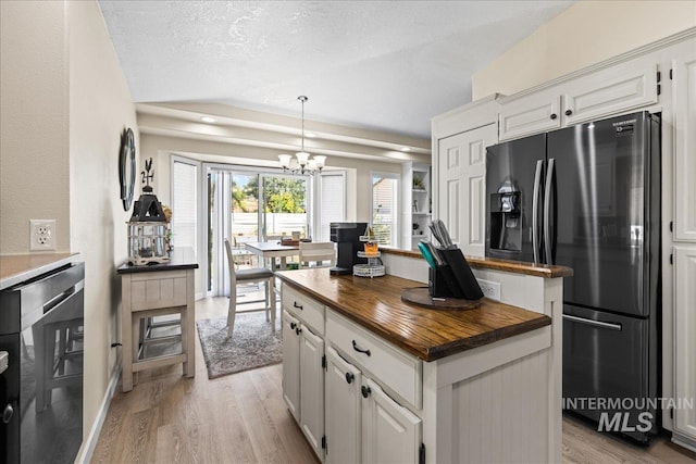 1902 E Birchwood Dr, Eagle, ID 83616 - kitchen with butcher block countertops, fridge with ice dispenser, a chandelier, light wood-style floors, and white cabinets
