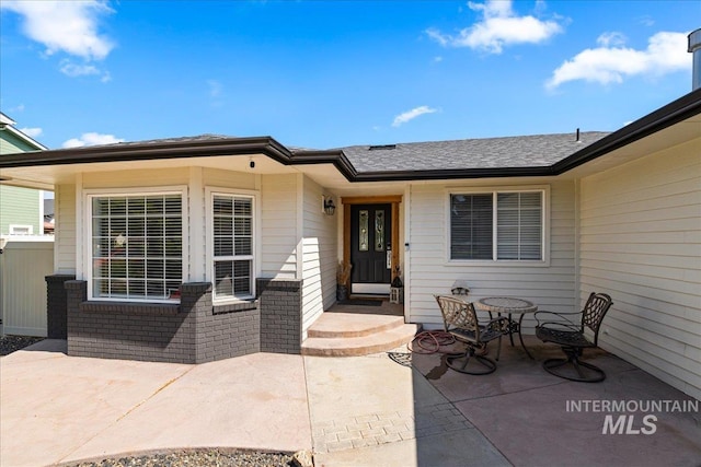 1902 E Birchwood Dr, Eagle, ID 83616 - entrance to property featuring a patio, roof with shingles, and brick siding