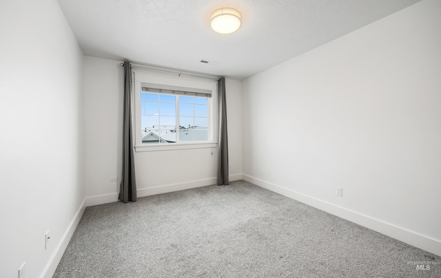 carpeted empty room with baseboards