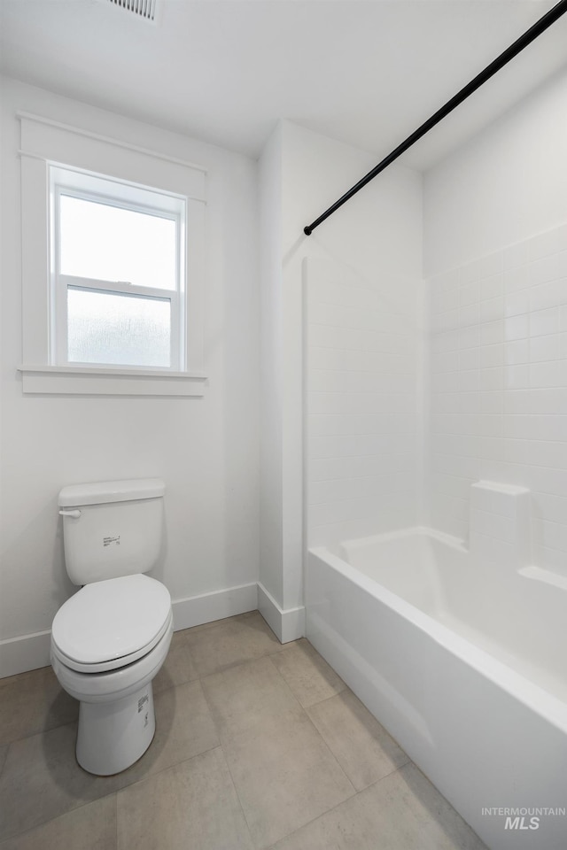 bathroom featuring tile patterned floors, baseboards, toilet, and bathtub / shower combination