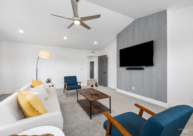 living area featuring a ceiling fan, vaulted ceiling, light colored carpet, and baseboards