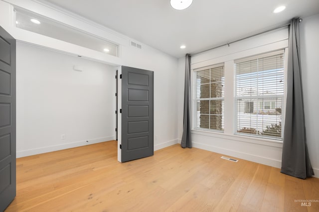 empty room with recessed lighting, light wood-style floors, visible vents, and baseboards