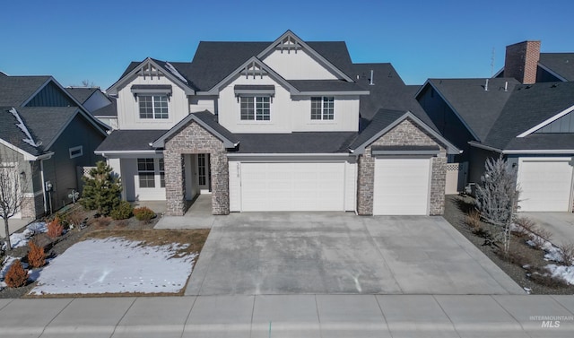 view of front facade featuring stone siding, driveway, and board and batten siding