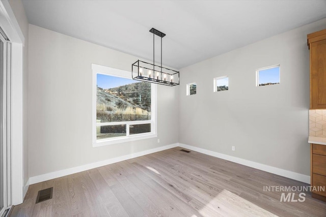 20042 N Swire Green Way Unit 459, Boise, ID 83714 - unfurnished dining area featuring a chandelier, wood finished floors, and baseboards